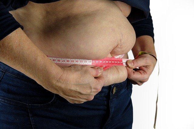 tlustá postava, která si měří tlusté břicho metrem.jpg