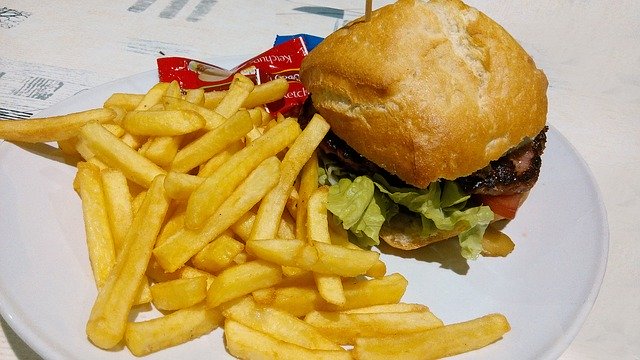 hamburger a hranolky na talíři s kečupem v malém plastovém pytlíčku.jpg